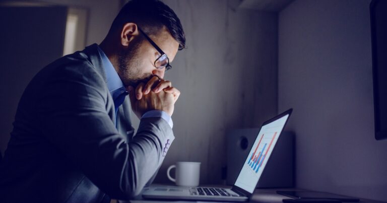 Man sitting at his desk and looking stress while using laptop
